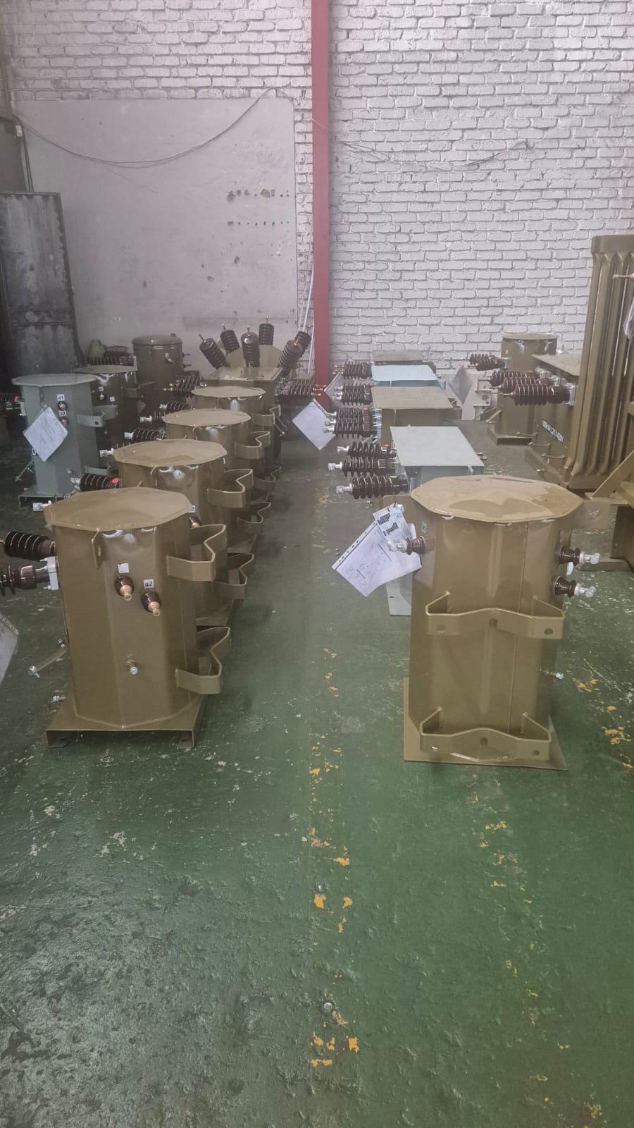 Pole-mounted distribution transformers lined up in the TNA workshop