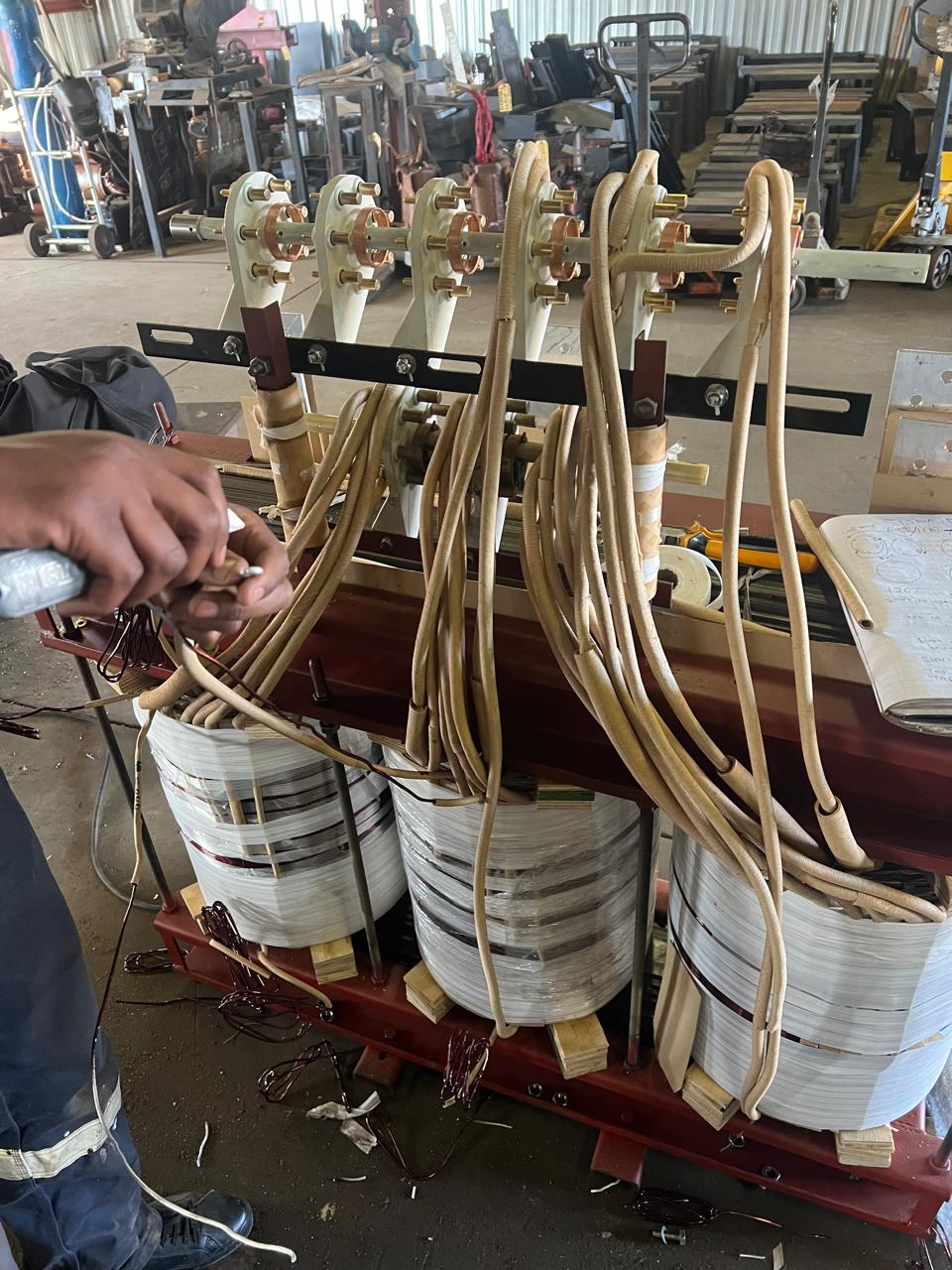 Technician working on transformer coil windings in the workshop